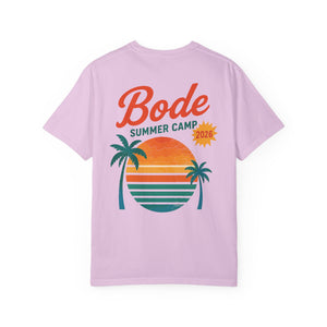 The BODE Summer Camp T-Shirt 2026—"Throwback Sunset" by Printify features a light purple heavyweight cotton Comfort Colors 1717 and a back graphic of two palm trees, striped sunset, and "Bode Summer Camp 2026" text—ideal for summer.