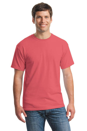 A man, smiling and facing forward, wears a Gildan Heavy 100% Cotton Custom T-Shirt (Gildan 5000) in coral pink with blue jeans against a white background.