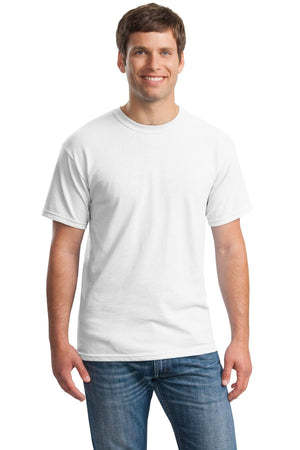 A man faces forward, smiling and wearing a Gildan Heavy 100% Cotton Custom T-Shirt (Gildan 5000) in plain white with short sleeves, paired with blue jeans, standing against a white background.