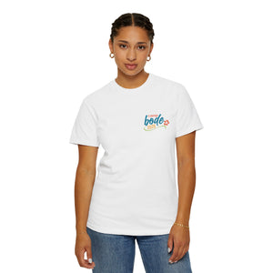 A woman stands facing forward against a white background, wearing Printify’s heavyweight cotton Summer Camp T-Shirt featuring the 'Life Is Better Together' beach can design and durable double-needle stitching, paired with blue jeans.