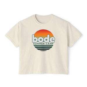 The 2026 Bode Summer Bootcamp - Cali Sunset Logo Crop T-Shirt by Printify features a boxy, cropped fit and soft ring-spun cotton, with "bode SUMMER CAMP" text and a sunset graphic in orange, yellow, and green.