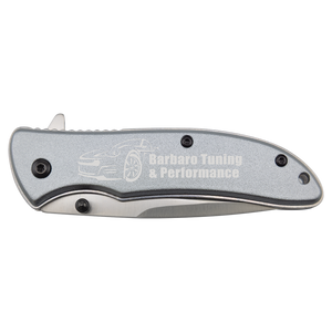 The Bison River Custom Laser Engraved 4 1/4" Everyday Carry Knife features a silver handle, custom-engraved with "Barbaro Tuning & Performance" and a car outline—perfect for corporate gifts or promotional giveaways.