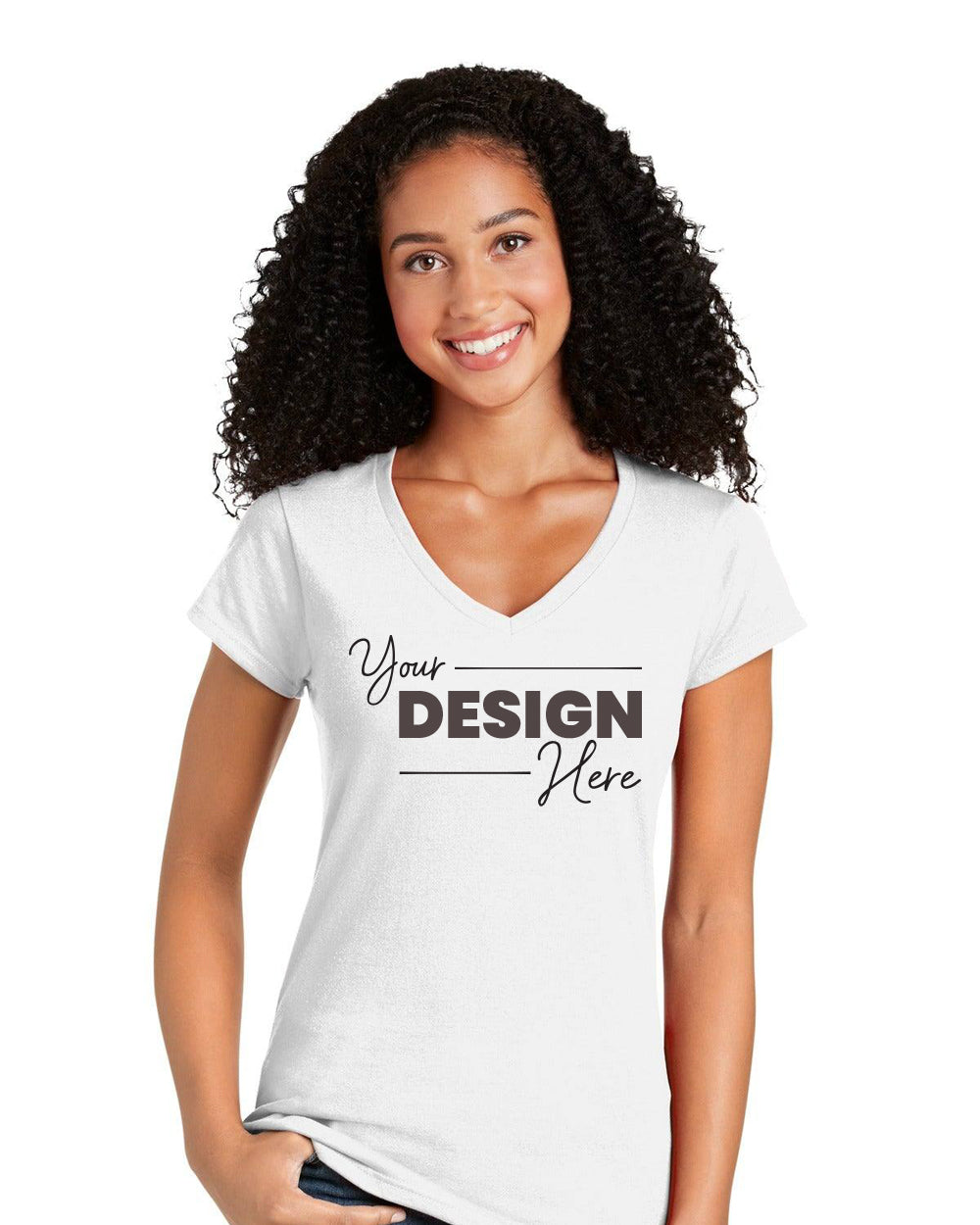 A woman with curly hair wears a Gildan Softstyle Ladies Fit V-Neck T-Shirt 64V00L in white with "Your Design Here" in black text, standing against a plain background. This Gildan tee is ideal for bulk custom orders.