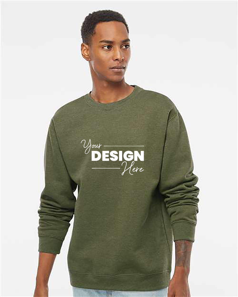 A young man wearing an olive green Independent Trading Co. Midweight 100% Cotton Crewneck Sweatshirt SS3000, featuring the text "Your Design Here" printed on the front.