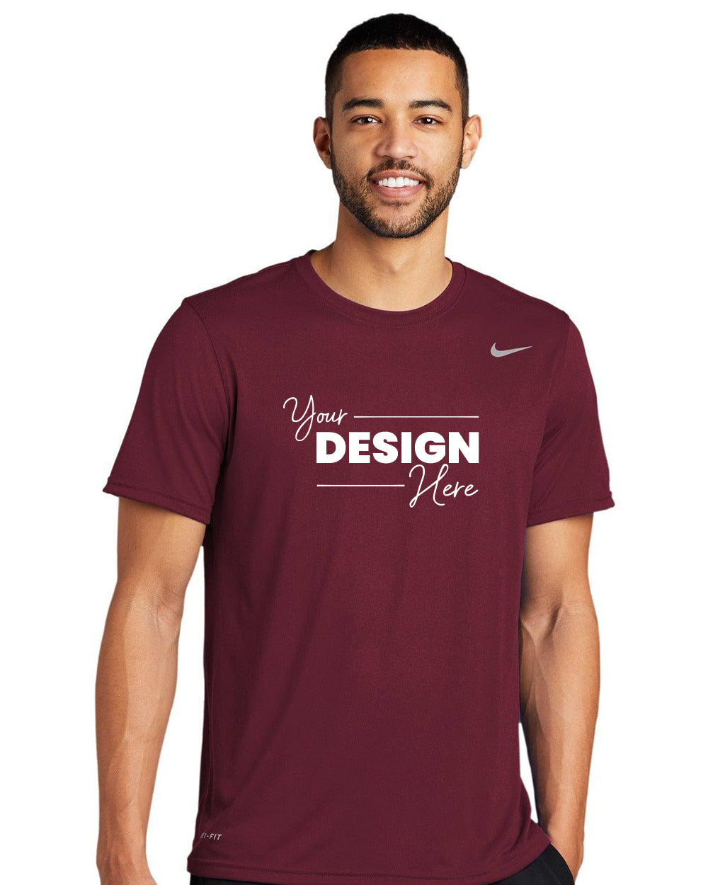 A man models a maroon Nike Legend T-Shirt 727982 featuring "Your Design Here" on the front. Made from polyester jersey with Dri-FIT technology, it offers comfort and style.