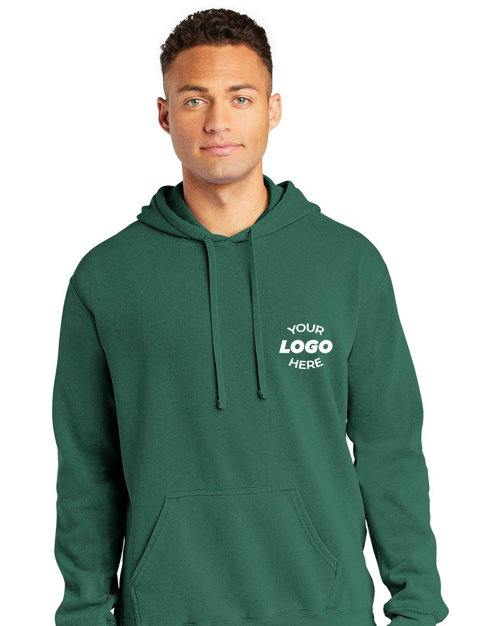 A man wearing a Comfort Colors Ring Spun Hoodie Sweatshirt 1567 in green, featuring a front pocket and "YOUR LOGO HERE" printed on the upper left chest.
