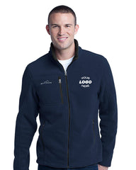 A person standing and smiling in a navy blue Eddie Bauer Full-Zip Fleece Jacket EB200 with 