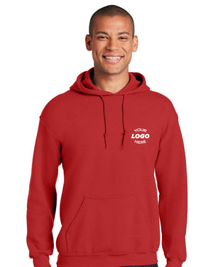 A person stands smiling in a vibrant red Gildan - Heavy Blend Hoodie Sweatshirt 18500 with "Your Logo Here" on the front, blending durable cotton/poly comfort with unique style.