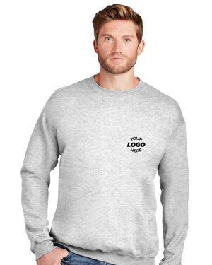 A man wearing a light gray Hanes Ultimate 100% Cotton Crewneck Sweatshirt F260 with "Your Logo Here" text on the left chest, standing against a white background.