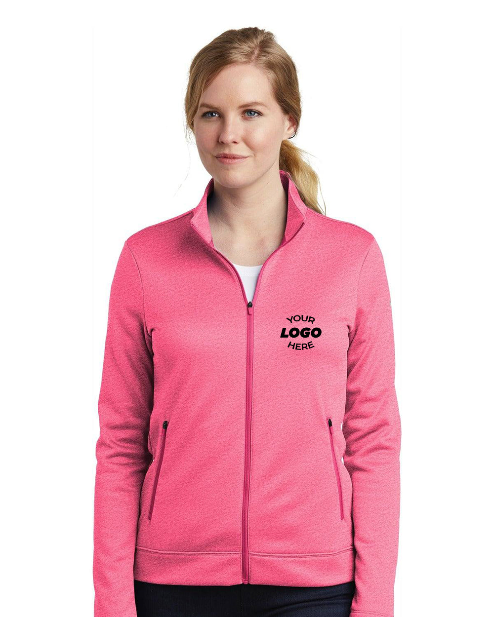 A person in a pink Nike Ladies Therma-FIT Full-Zip Fleece NKAH6260, featuring "Your Logo Here" on the left chest. Perfect for cold-weather workouts, it offers a feminine fit combining warmth and style.