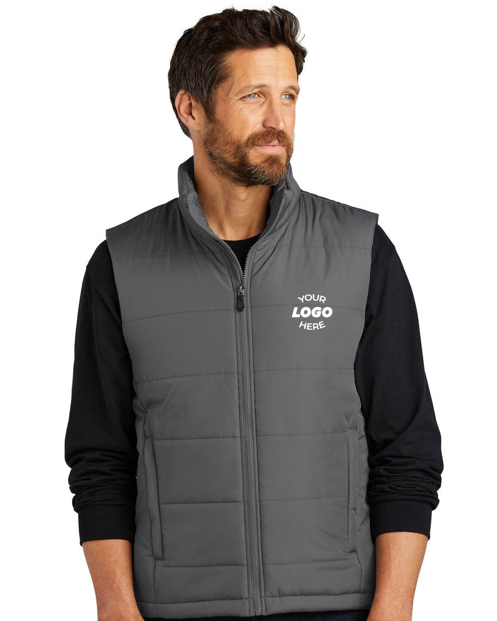 A man wears a Port Authority Puffer Vest J853 in gray with polyfill insulation over a black shirt, featuring "YOUR LOGO HERE" on the left chest.