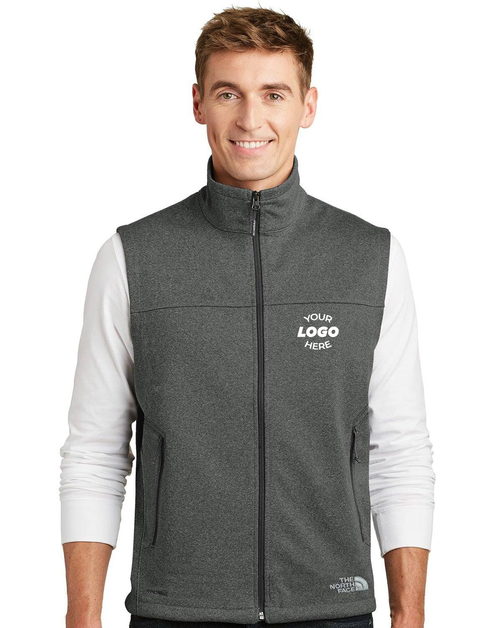 A man wears a gray The North Face Ridgewall Soft Shell Vest NF0A3LGZ over a white long-sleeve shirt, featuring "YOUR LOGO HERE" printed on the left chest of the vest.