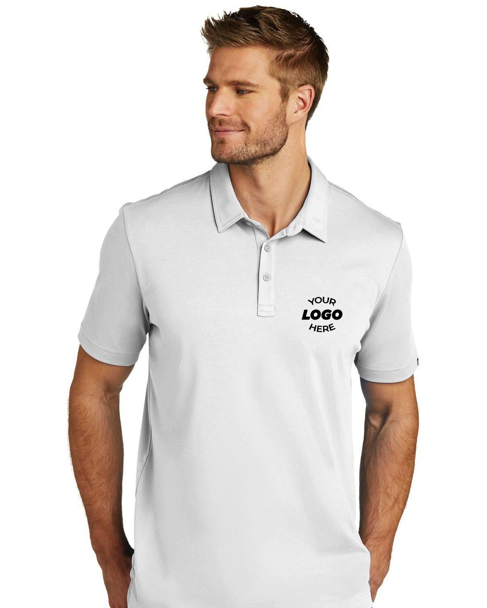 Man wearing a TravisMathew Oceanside Solid Polo TM1MU411 in plain white with "YOUR LOGO HERE" on the left chest, made from quick-drying performance fabric by TravisMathew, standing and looking to the side.