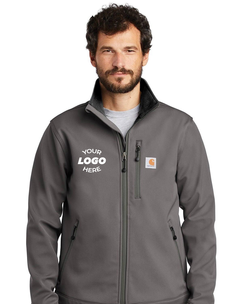 A man is wearing a Carhartt Crowley Soft Shell Jacket CT102199, a water-resistant, relaxed-fit gray jacket with space for a logo on the left side.