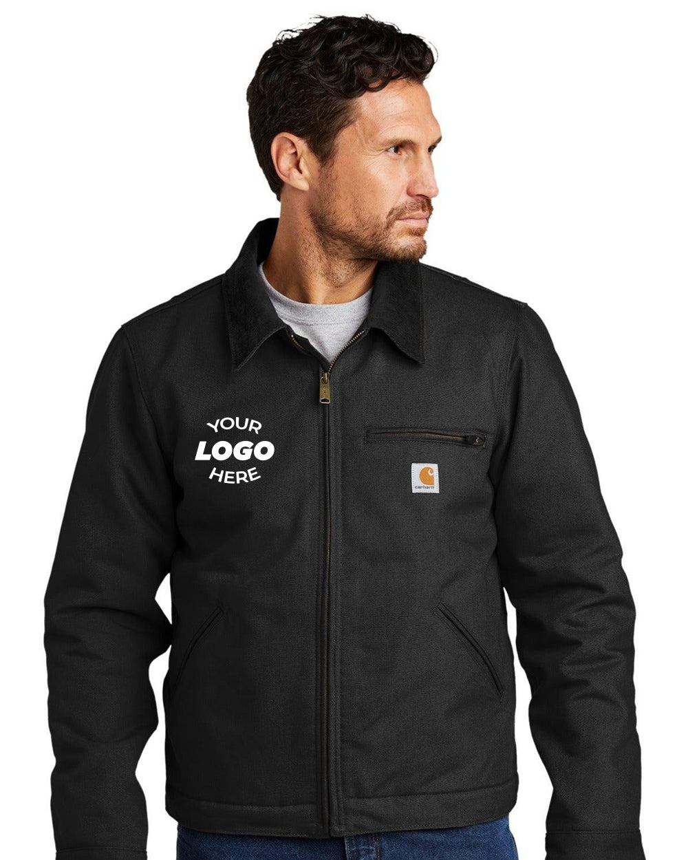 A man wears a black Carhartt Duck Detroit Jacket CT103828, featuring durable cotton duck canvas, the Carhartt logo on the chest pocket, and "YOUR LOGO HERE" on the left side.