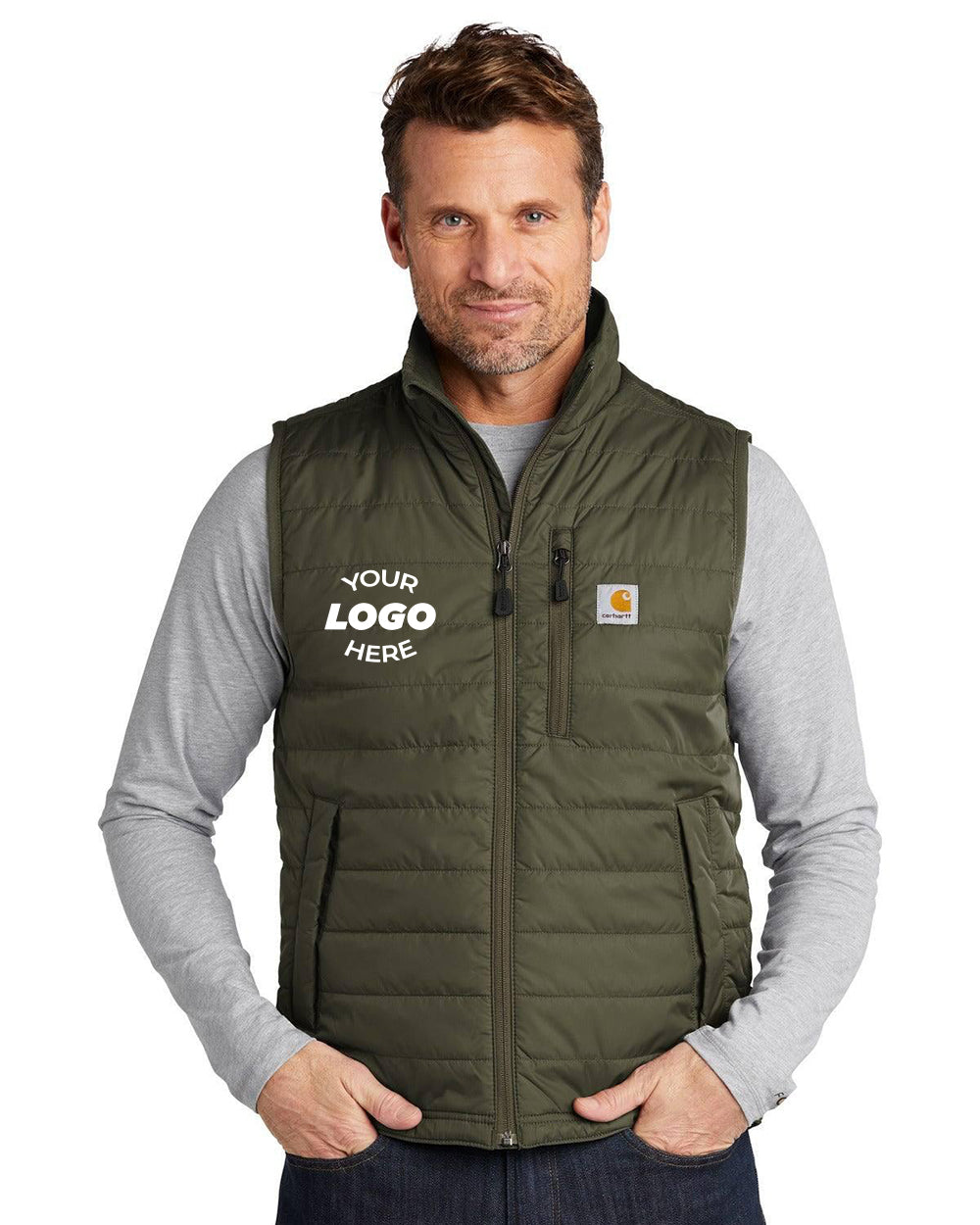 Wearing the Carhartt Gilliam Vest CT102286 in green, customized with "Your Logo Here" on the left side, this person keeps their hands cozy in the pockets. This rugged workwear vest is teamed with a gray shirt, providing both style and water-repellent protection.
