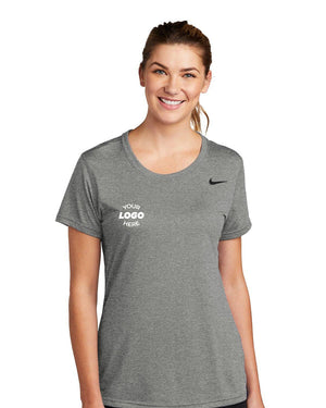 A smiling woman wearing a gray Nike Ladies Legend T-Shirt CU7599, designed with Dri-FIT technology and a placeholder text for a custom logo.
