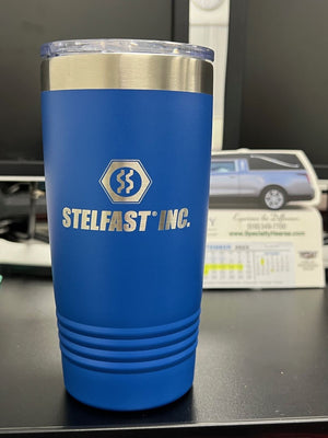 A blue insulated tumbler with Kodiak Coolers logo, a corporate promotional gift, placed on a desk with a business card holder and cards in the background.