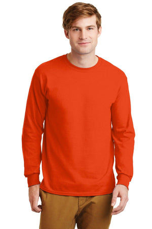 A man wearing a Gildan 100% US cotton long sleeve T-shirt (Pack of 36, style 2400) with a custom screen printed logo and brown pants stands facing forward against a plain white background.