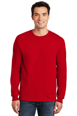A man in jeans and a plain red long-sleeve shirt smiles, modeling the Gildan (Pack of 36) 100% US Cotton Long Sleeve T-Shirt 2400, which includes custom screen printed logos.