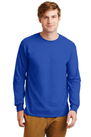 A man wearing a plain royal blue Gildan 100% US Cotton Long Sleeve T-Shirt (Pack of 36, custom screen printed logo included) and tan pants, standing forward with a neutral expression.