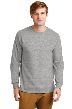 A man in tan pants and a plain gray Gildan 100% US Cotton Long Sleeve T-Shirt 2400 with custom screen printed logo stands facing forward against a white background.