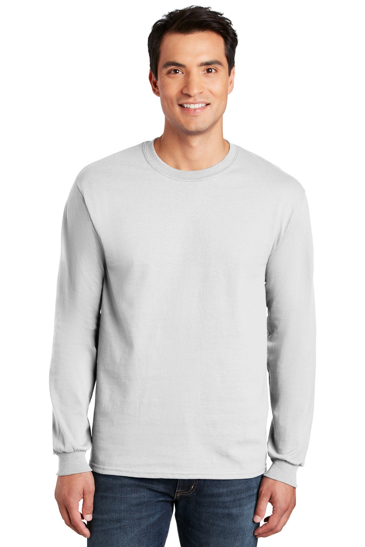 A man in dark jeans smiles at the camera, wearing a Gildan 100% US Cotton Long Sleeve T-Shirt (Pack of 36, style 2400) with a custom screen-printed logo included.