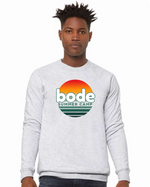 A person wears the designerapp Bode Summer Bootcamp "OG Logo" Unisex Crewneck BC Fleece Raglan Sweatshirt 3901, featuring a sunset logo on light gray, made from soft Airlume cotton and printed via Direct to Garment technology.