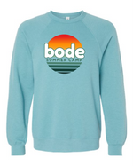 The designerapp Bode Summer Bootcamp "OG Logo" unisex crewneck BC Fleece Raglan Sweatshirt 3901 features a retro logo and sunset graphic on light blue, pre-shrunk Airlume combed cotton for a soft, lasting fit.