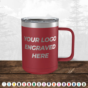Red insulated mug with a handle on a wooden table, featuring the text "TODAY ONLY - Custom Logo Drinkware Sale - Your Logo Laser Engraved INCLUDED in Price - No Hidden Fee's" on its side, with a blurred forest background by Kodiak Coolers.