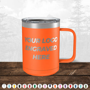 A promotional gift, a TODAY ONLY - Custom Logo Drinkware Sale - Your Logo Laser Engraved INCLUDED in Price - No Hidden Fee's insulated mug with a handle and a customizable area for a custom logo, displayed on a wooden surface against a blurred forest background from Kodiak Coolers.