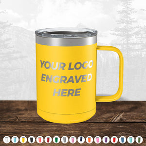 A yellow insulated tumbler with a metallic lid and handle, featuring the text "TODAY ONLY - Custom Logo Drinkware Sale - Your Logo Laser Engraved INCLUDED in Price - No Hidden Fee's," displayed on a wooden surface against a blurred forest background by Kodiak Coolers.