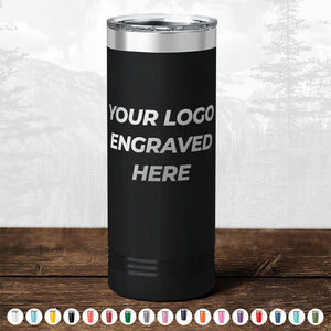 A black insulated tumbler from Kodiak Coolers with "TODAY ONLY - Custom Logo Drinkware Sale - Your Logo Laser Engraved INCLUDED in Price - No Hidden Fee's" text, displayed on a wood table with a blurred forest background, perfect as a promotional gift.