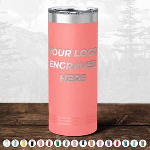 A pink insulated tumbler custom printed with "TODAY ONLY - Hump Day Sale - Your Logo Engraved on Drinkware - Single Side Engraving Included in Price - Slider Lids Included," placed on a wooden surface against a blurry forest background by Kodiak Coolers.
