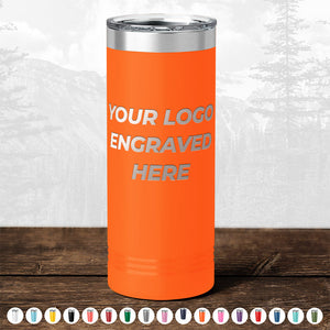 Orange insulated tumbler from Kodiak Coolers with "TODAY ONLY - Custom Logo Drinkware Sale - Your Logo Laser Engraved INCLUDED in Price - No Hidden Fee's" text, displayed on a wooden surface against a blurred forest backdrop.