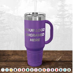 A purple insulated travel mug with a handle and a straw, custom printed with "your logo here" on its side, displayed on a wooden surface with a misty forest background. TODAY ONLY - Hump Day Sale - Your Logo Engraved on Kodiak Coolers - Single Side Engraving Included in Price - Slider Lids Included