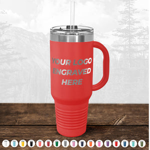 Red insulated tumbler with a handle and straw, featuring the text "TODAY ONLY - Custom Logo Drinkware Sale - Your Logo Laser Engraved INCLUDED in Price - No Hidden Fee's" on a wooden surface, with a blurred forest background by Kodiak Coolers.