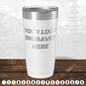 Stainless steel tumbler with personalized engraving space, displayed on a wooden surface, with a blurred forest background from TODAY ONLY - Custom Logo Drinkware Sale by Kodiak Coolers.