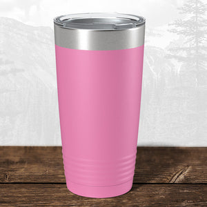 A 20 oz Wisconsin Green Bay Bulldogs tumbler by Kodiak Coolers, featuring a laser-engraved design and silver lid, sits on a wooden surface with a blurred mountain background.