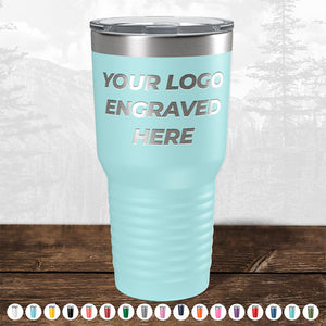 The limited-time-sale Kodiak Coolers light blue custom tumbler with laser-etched logo and “Your Logo Engraved Here” text is elegantly displayed on wood. Perfect for corporate gifts, with various colors available. Open mouth lid included, no setup fees.