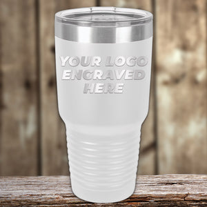 A white Kodiak Coolers Custom Tumbler with a clear lid rests on wood, featuring your engraved logo or design—ideal for personalized mugs or promotional gifts. No setup fees; $200 minimal order.