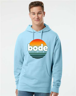 Someone wearing the Printify 2026 Bode Summer Bootcamp OG Logo Hoodie Sweatshirt (Unisex, Independent Trading Co. SS4500), featuring a light blue cotton-poly fleece and sunset graphic on the front with an adjustable hood.