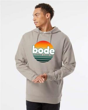 A man wears a light gray Printify 2026 Bode Summer Bootcamp OG Logo Hoodie Sweatshirt (Unisex, Independent Trading Co. SS4500) with a sunset graphic and "bode SUMMER CAMP '26" logo on the chest.