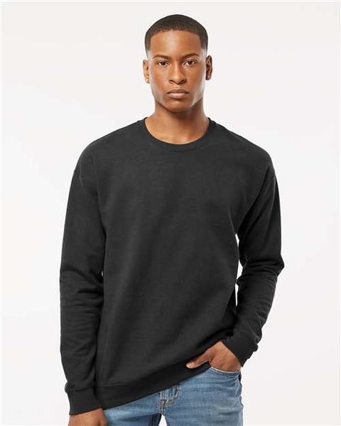 A man wearing a Tultex Unisex Fleece Crewneck Sweatshirt and jeans made of heather grey ringspun cotton/polyester fabric.