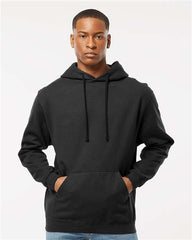 A man wearing a Tultex Unisex Fleece Hoodie Sweatshirt and jeans made of ringspun cotton/polyester fabric. The hoodie, produced by Tultex, has a tear away label and comes in solid colors.