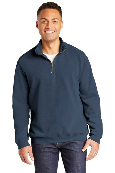 A smiling person wearing a navy Comfort Colors Ring Spun 1/4-Zip Pullover 1580, crafted from soft cotton, along with jeans, stands against a white background.