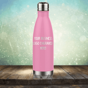 Promotional pink stainless steel tumbler from Kodiak Coolers with customizable logo area displayed on a wooden surface against a bokeh background.