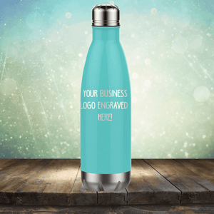 Promotional mockup of a Kodiak Coolers SECOND CHANCE SALE - Custom Engraved Drinkware blue insulated stainless steel tumbler on a wooden surface with a bokeh background.