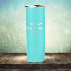 Customizable teal stainless steel tumbler with engraving space for a custom logo promotional gift from Kodiak Coolers, displayed on a wooden surface against a bokeh background.
