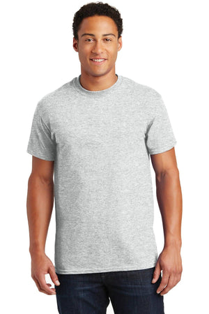 A person wearing a plain gray Gildan - 100% US Cotton T-Shirt 2000 and dark jeans stands against a white background, highlighting the simplicity and comfort of this all-cotton garment, perfect for any promotional materials.